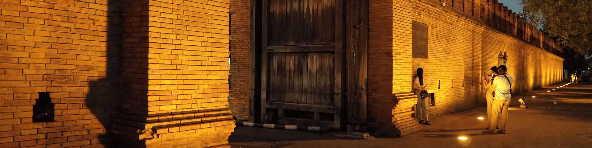 A brick building with a large wooden door at dusk.
