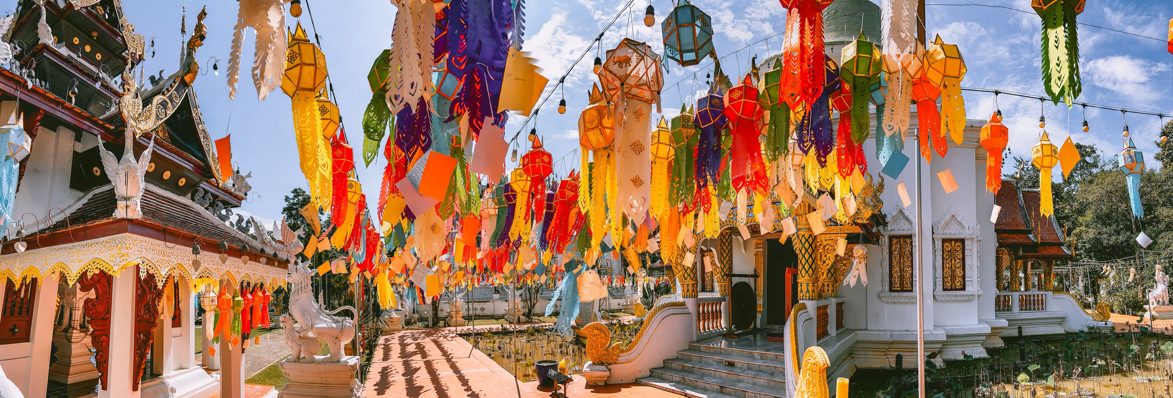 A temple with colorful paper lanterns hanging from the ceiling and intricate architecture.