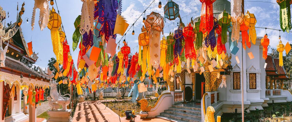 A temple with colorful paper lanterns hanging from the ceiling and intricate architecture.