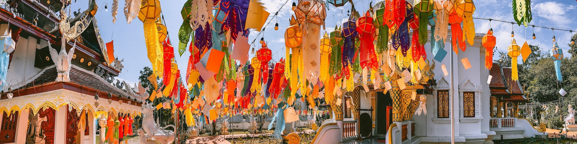 A temple with colorful paper lanterns hanging from the ceiling and intricate architecture.