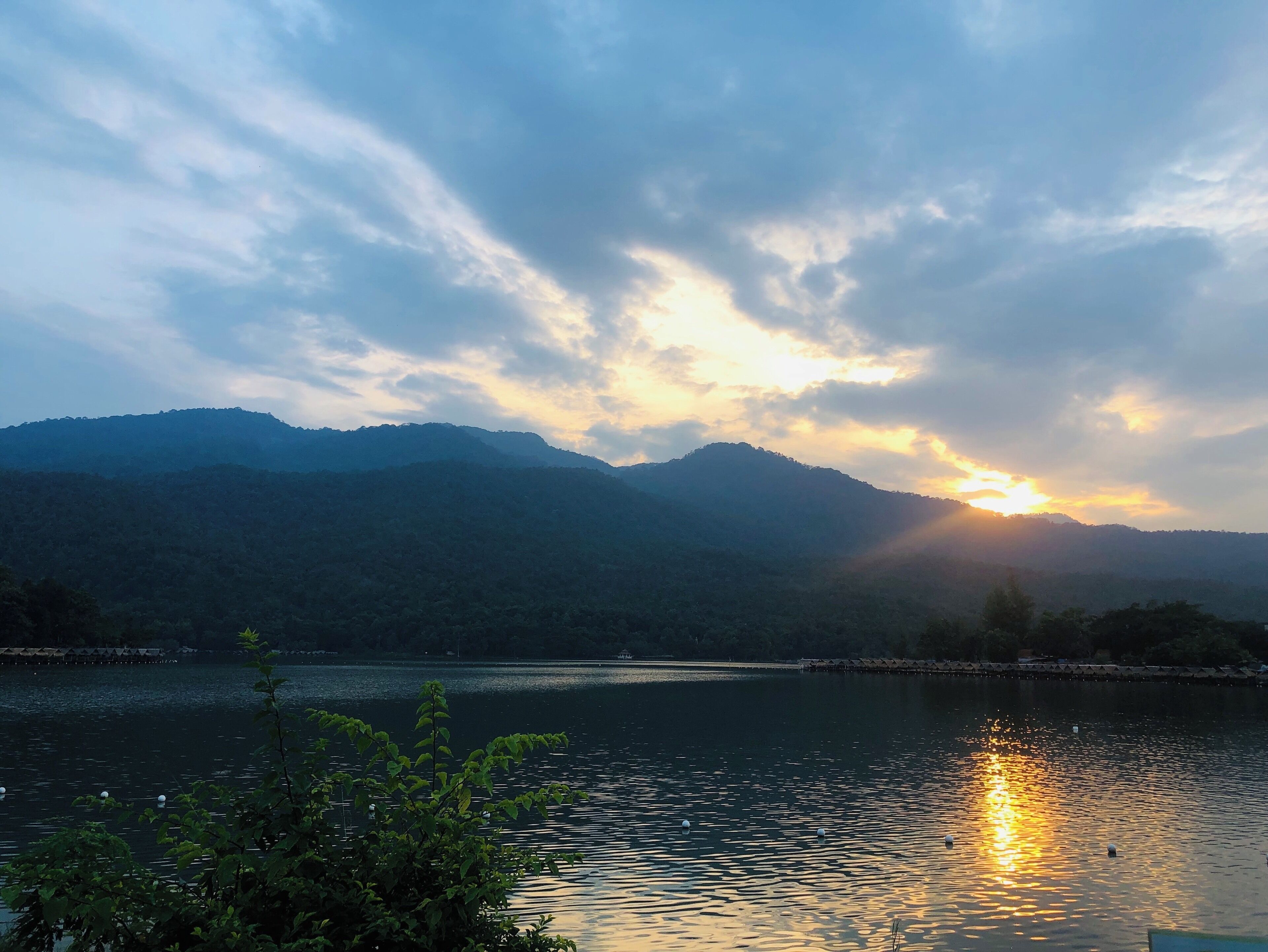 A sunset over a lake with mountains in the background.
