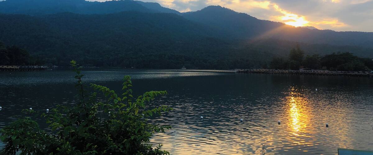 A sunset over a lake with mountains in the background.