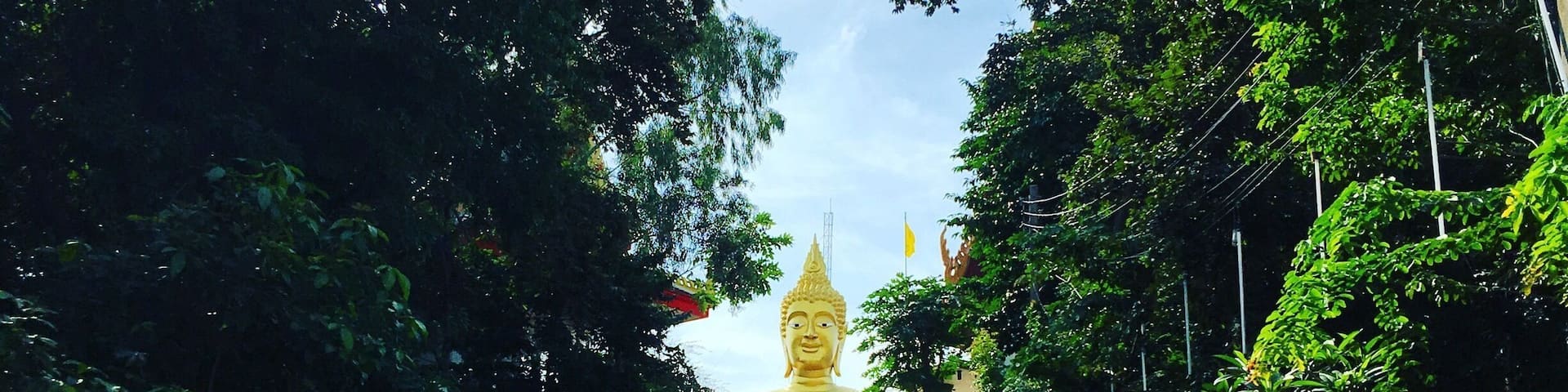 A staircase leading to a large golden statue surrounded by trees.