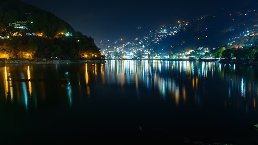 Nightscape of Nainital city with city light reflection on Naini Lake in Uttrakhand, India