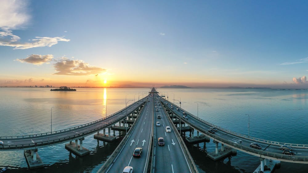 Cars driving across Penang bridge at sunrise, Penang, Malaysia