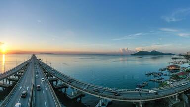Cars driving across Penang bridge at sunrise, Penang, Malaysia