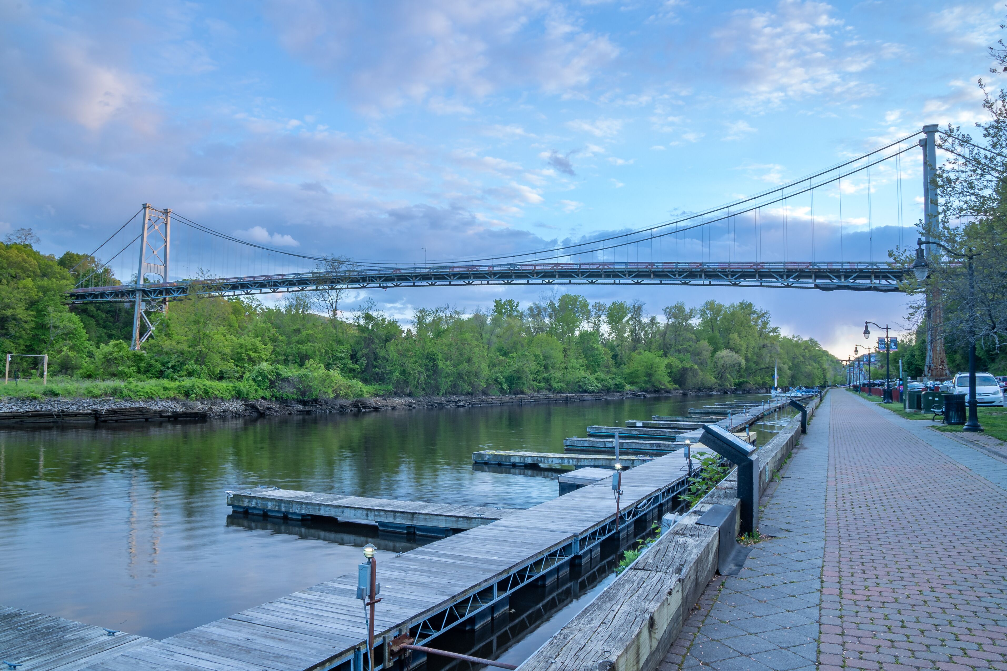 Kingston, NY - USA- May 12, 2021: a landscape view of the Wurts Street Bridge or the The Kingston–Port Ewen Suspension Bridge, is a steel suspension bridge spanning Rondout Creek.