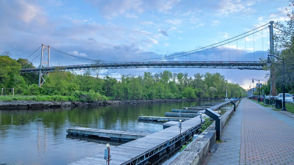 Kingston, NY - USA- May 12, 2021: a landscape view of the Wurts Street Bridge or the The Kingston–Port Ewen Suspension Bridge, is a steel suspension bridge spanning Rondout Creek.