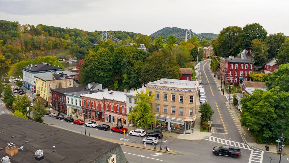 A town with historic buildings, a river, and a bridge in the background.