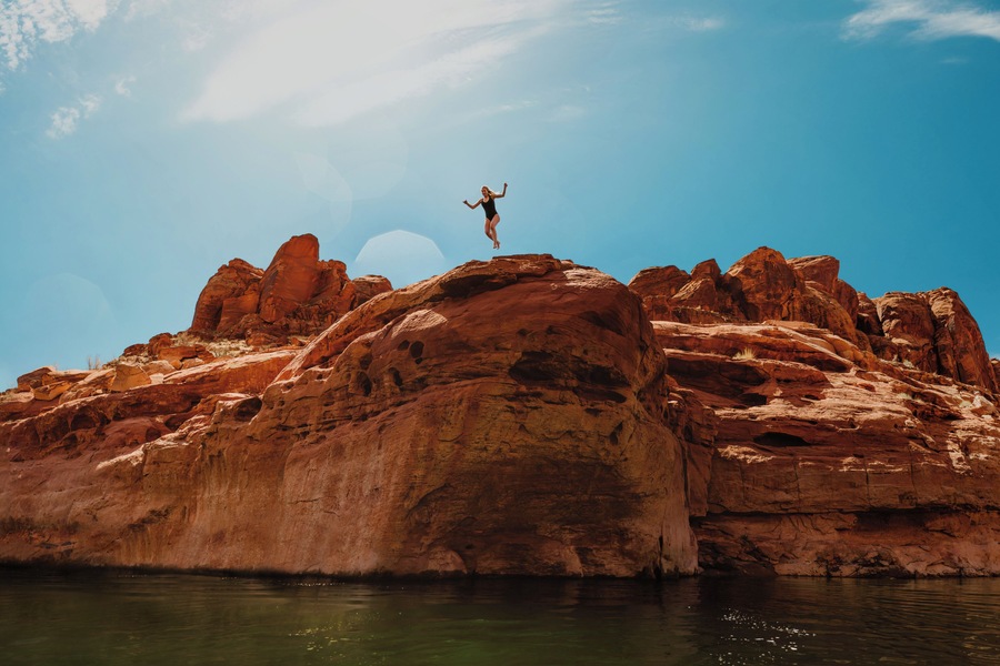 Nothing says adventure like facing your fears head on with an adventure buddy. I had already made the jump, and this is my friend, Brooke, taking the leap while I floated on a kayak below. It takes an adventurous spirit to see the stomach-dropping fear in front of you, and take the leap to overcome it.
Lake Powell is a great spot to find epic rock climbing and cliff jumping. Those who manage to complete the epic climb are rewarded with the thrill of an epic jump! But it is important to always take every precaution, and always check the depth of the water prior to jumping. We found this cliff a swim away from our campsite at Lake Powell. #adventure #cliffjumping
