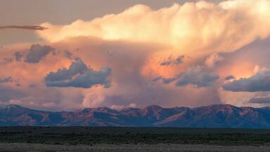 A mountain range with a dramatic sky at sunset.