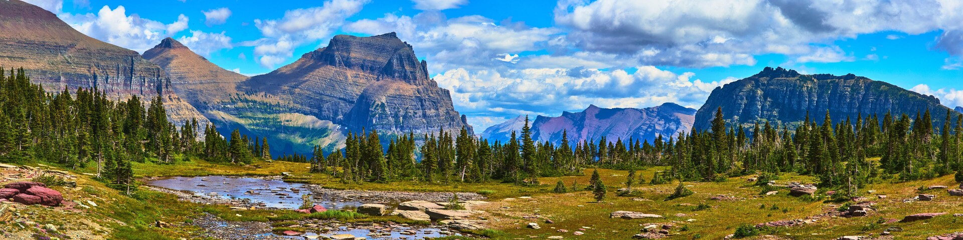 A mountainous landscape with a river, dense forests, and rocky terrain.