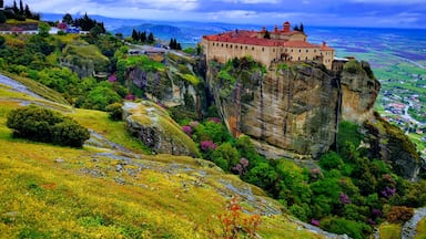 Un castillo se alza sobre un acantilado rocoso, con vistas a un valle.