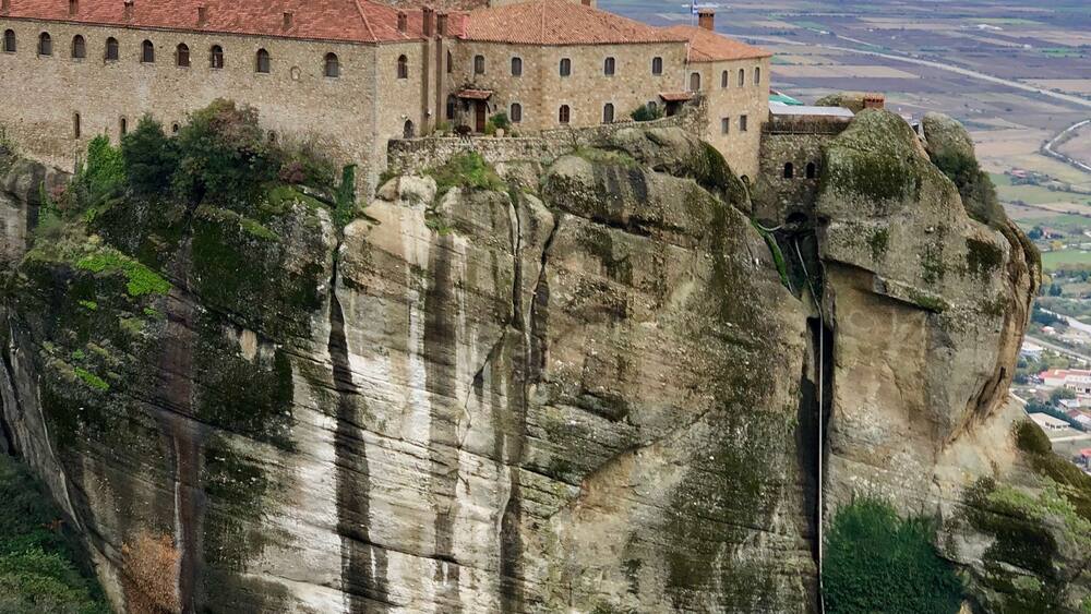Ein historisches Gebäude thront auf einem steilen Felsen mit weitreichendem Panoramablick auf die Landschaft.