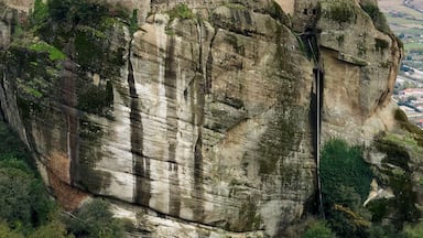 Um edifício histórico empoleirado no topo de um penhasco rochoso, com vista panorâmica da paisagem.