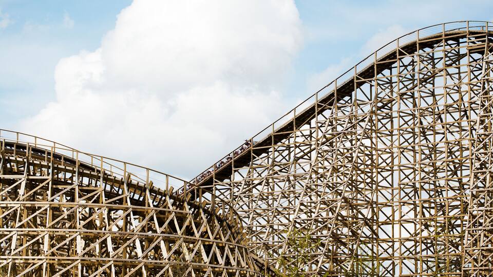 A large wooden roller coaster structure with a complex lattice design.