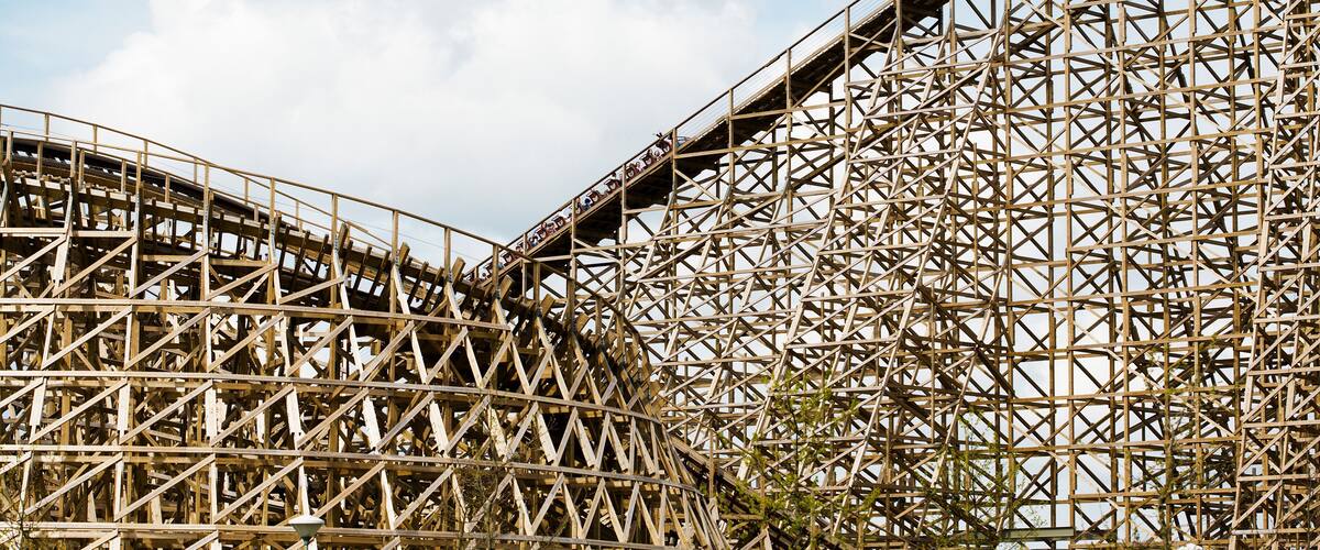 A large wooden roller coaster structure with a complex lattice design.