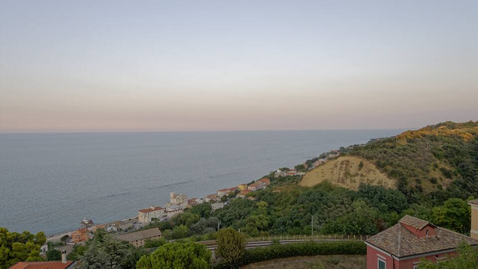 A coastal town with buildings along the hillside and a view of the sea.