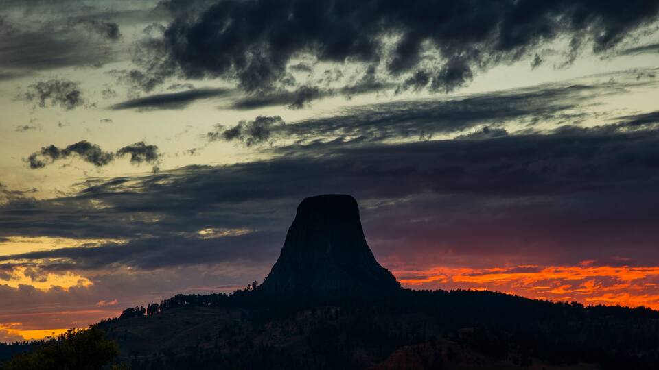 A mountain silhouette against a sunset sky.