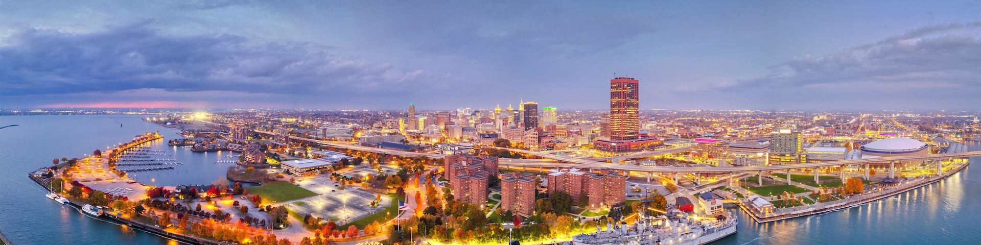 A cityscape with a prominent tower, waterfront promenade, and interconnected bridges.