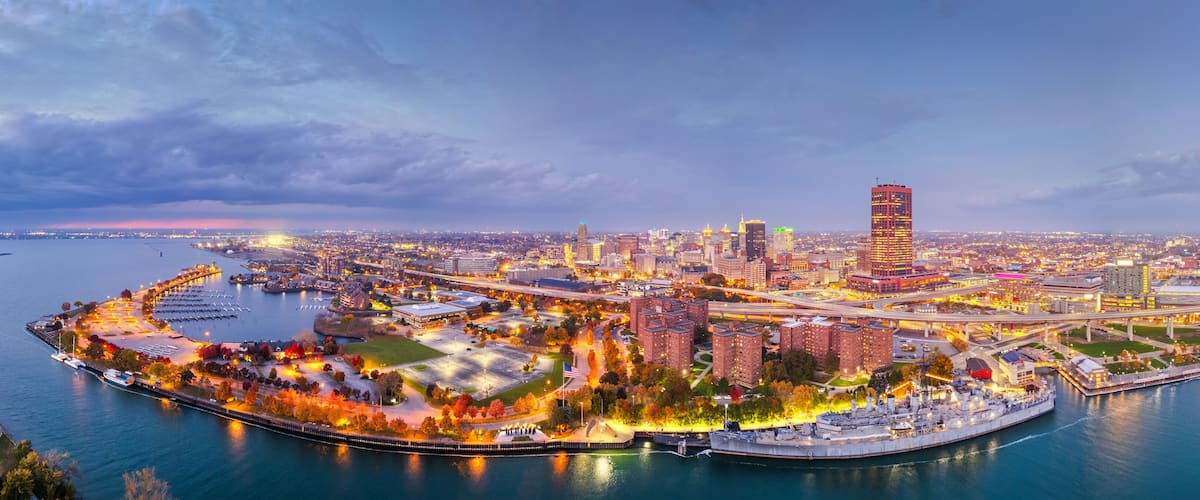 A cityscape with a prominent tower, waterfront promenade, and interconnected bridges.