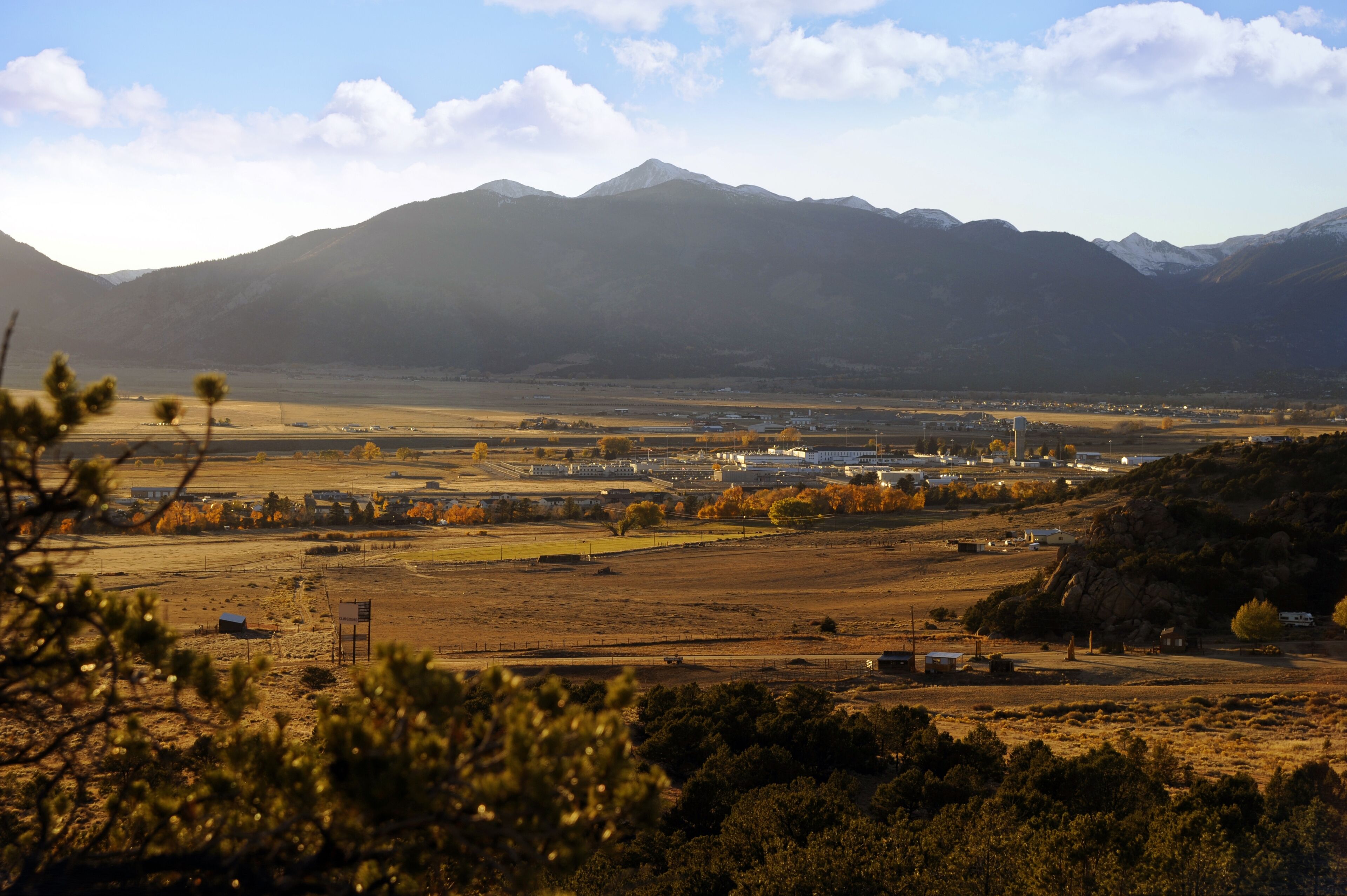 A mountainous landscape with a valley, fields, and a small settlement.