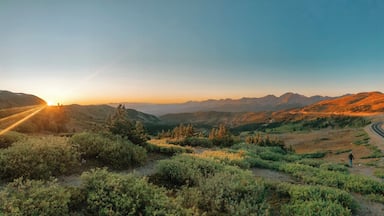 A mountainous landscape with a winding road and a person walking.