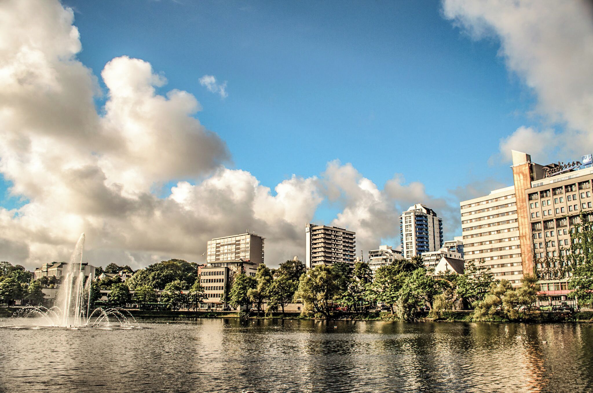 Reflected skyline in large lake in city centre.