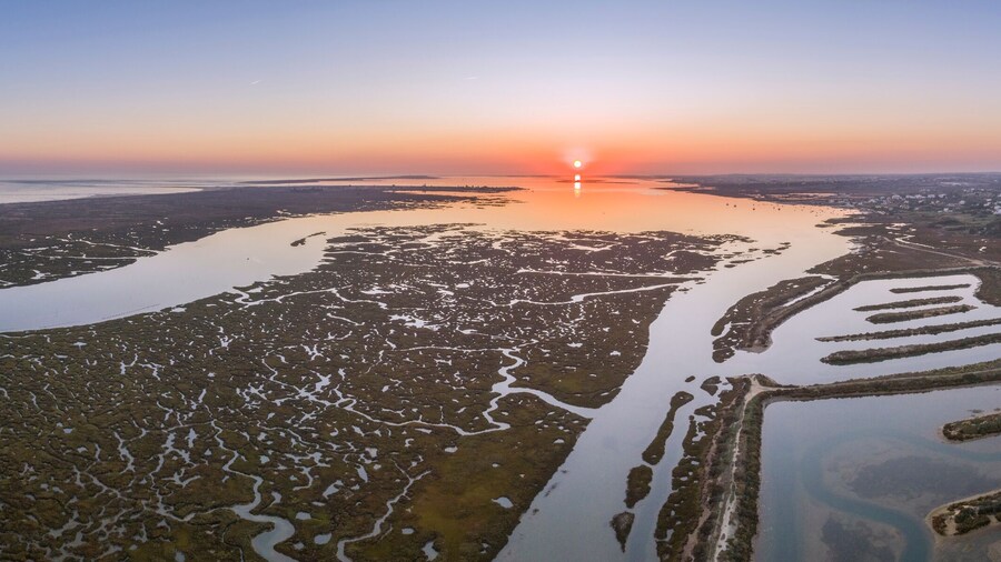 Aerial sunset seascape in Ria Formosa wetlands natural park, inland maritime channel. Algarve.