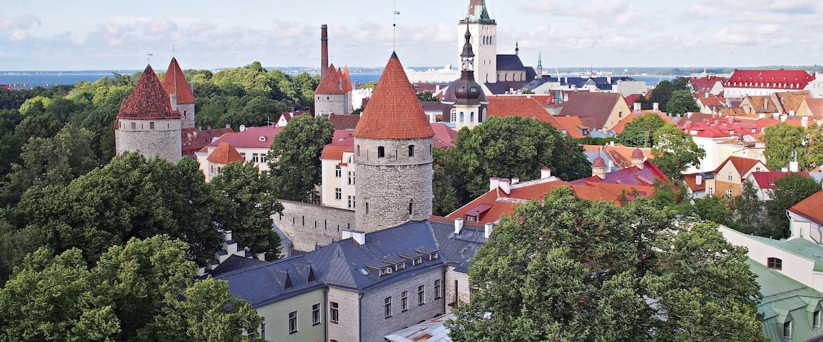 A historic town with red-roofed buildings, a prominent church tower, and a large church with a tall spire.
