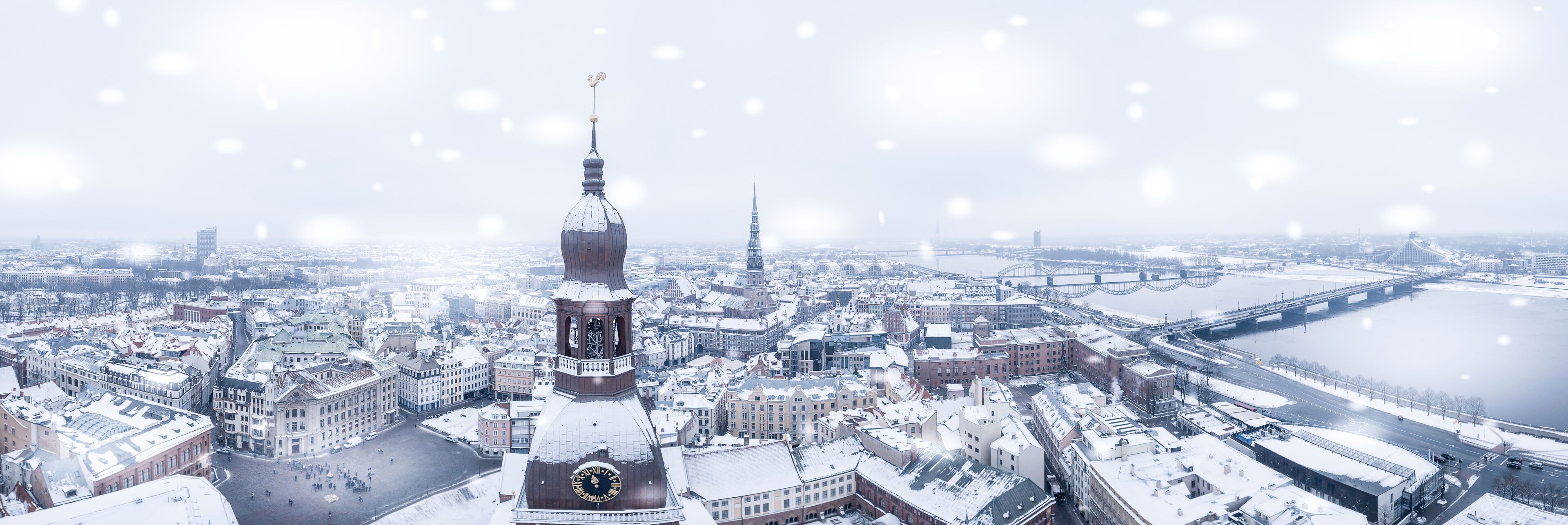 Amazing aerial view of the Riga old town (vecriga) in January during barracades memorial winter day. Snowing in Latvia.
