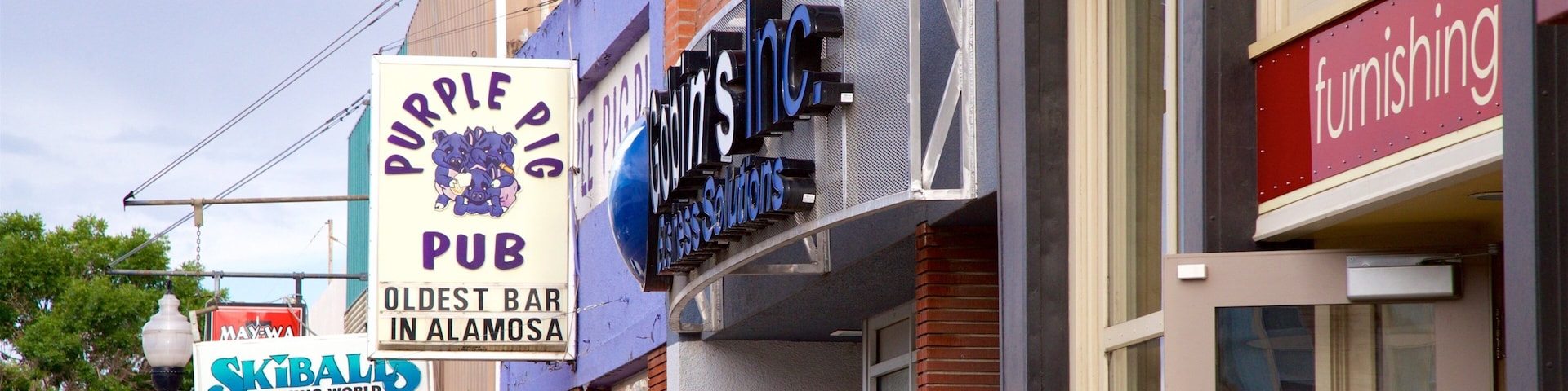 A street with various business signs including Coors, Purple Pig Pub, and Running World Athletic Apparel.