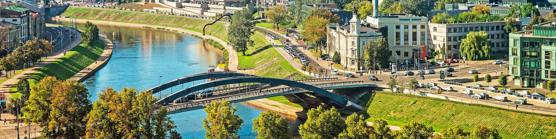 A cityscape with a river, modern buildings, and a bridge.