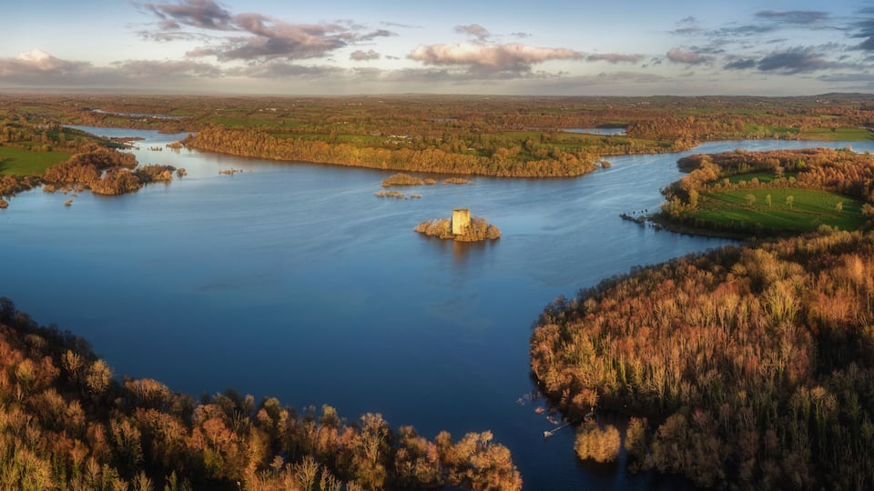 A river meandering through a forested landscape with a prominent island in the center.