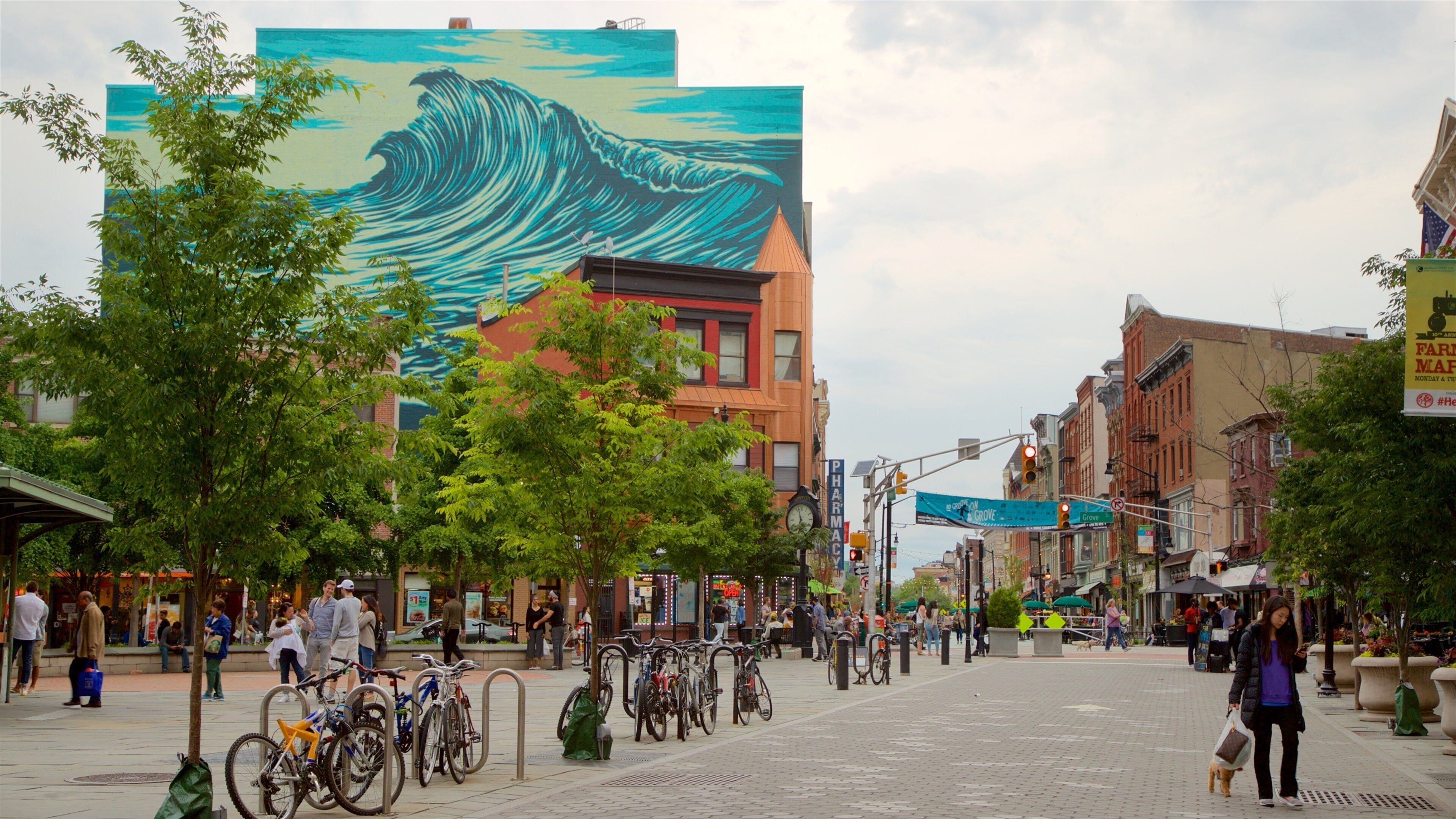 Downtown Jersey City which includes outdoor art and a city as well as an individual femail