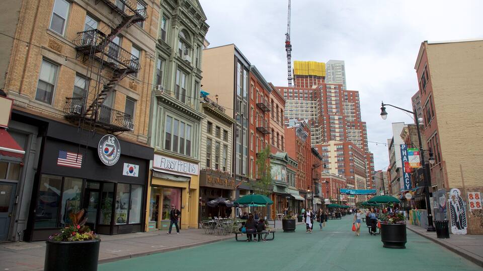 A street lined with historic buildings, a green bike lane, and outdoor seating areas.