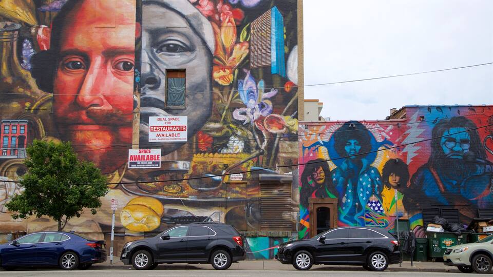 A mural on a building with cars parked in front.