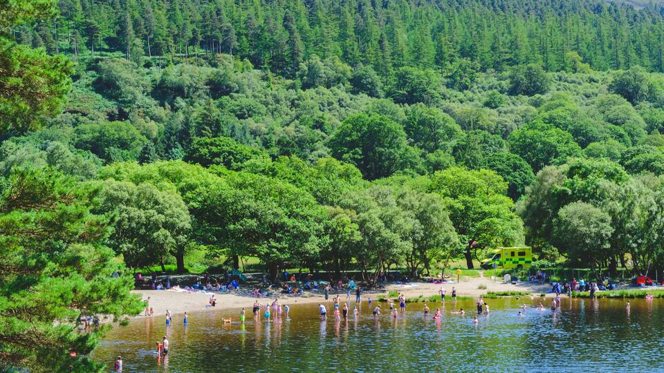 people enjoying in lake and mountain