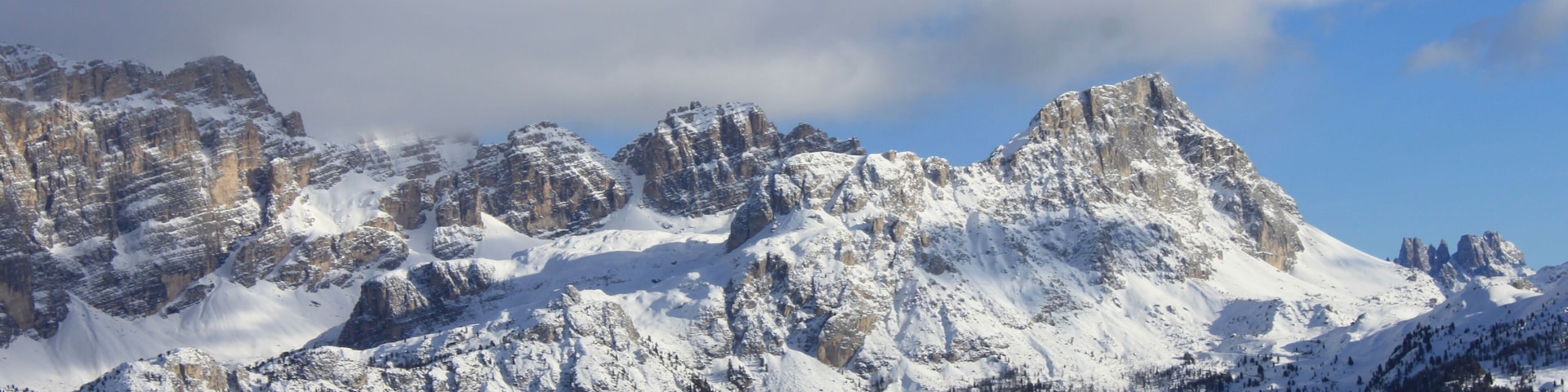 Una cordillera nevada con picos escarpados y un cielo azul despejado.