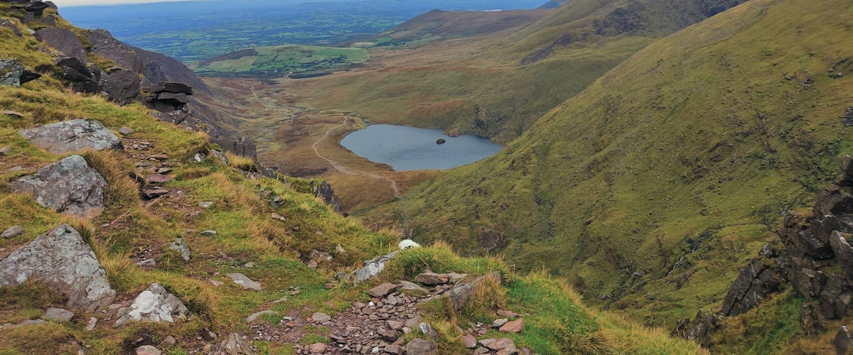 A mountainous landscape with a lake and a winding path.