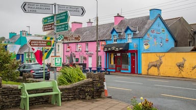 Colorful buildings, a green bench, and directional signs.