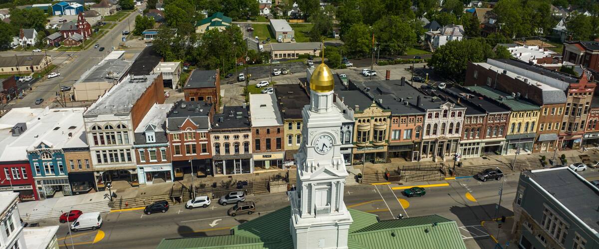 A historic downtown area with a prominent clock tower and a green-roofed building.