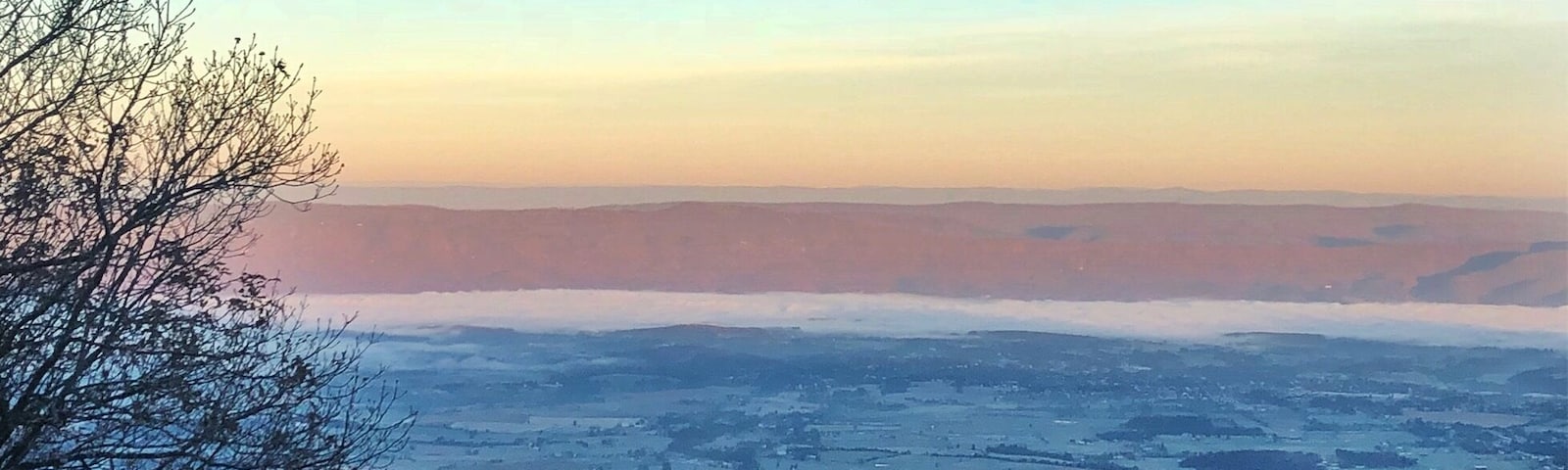 Just by the Skyland amphitheater is a building, on the top of an incline, facing west to Luray down below. There are four rooms here all with this breathtaking view made all the more gorgeous as the sun travels overhead and changes the color of the world below. At night, the stars are so vibrant that they can be seen while laying in bed. In the evening, the sunset is such an explosion of color it paints the walls. But in the early morning hours as the sun rises, it climbs on the other side of the mountain and slowly, gently, spreads over the valley floor. On this particular morning, it was below freezing and fog spread out through the valley, looking like a white ocean with waves that billowed and changed. The sun slowly burned away the fog, exposing a frost-covered land, and for a moment it felt like we were viewing the depths of a snowflake. 
If you go to Skyland Resort in Shenandoah, spend the extra bucks for a good room with a view. Nearly all rooms overlook this valley in some way, but we splurged for a king bed and were so lucky to see this sight every morning with a warm cup of coffee in hand.
#findyourpark #mountains #nature #virginia #hiking #roadtrips