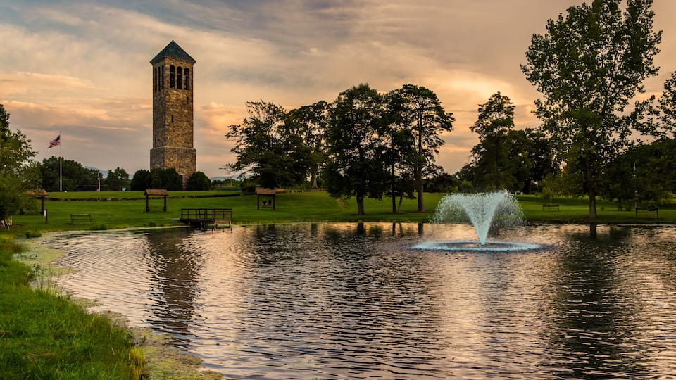 A tower, a fountain, and trees in a park.