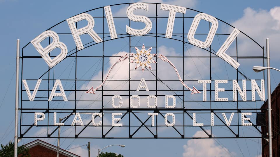 A sign with the words "BRISTOL VA GOOD PLACE TO LIVE" against a clear sky.