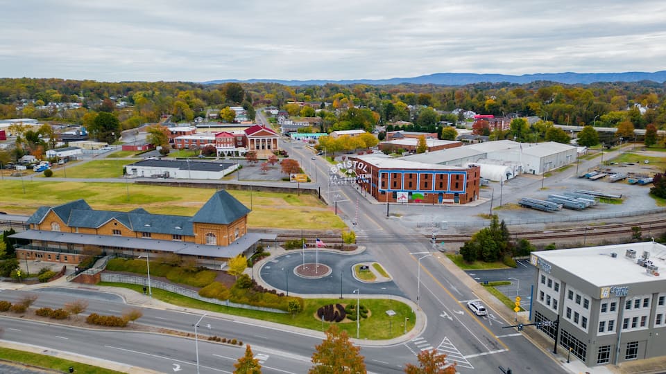 A town with a roundabout, a bank, and a large building with a red roof.