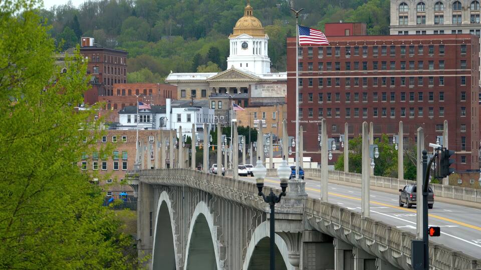 A bridge with arches, a clock tower, and a building with a golden dome.