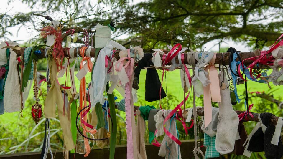 A clothesline with various garments and accessories hanging in an outdoor setting.