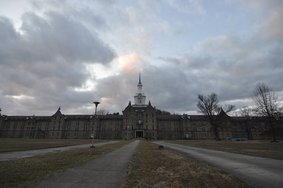 Un grand bâtiment historique doté d’une tour imposante et d’une façade symétrique.