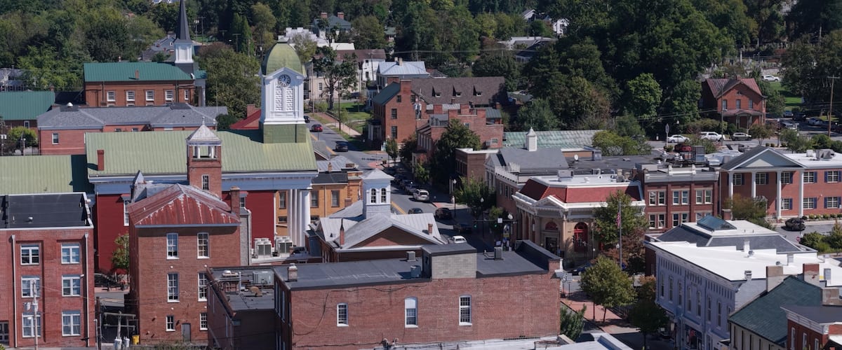 A town with historic buildings, a prominent clock tower, and a water tower.